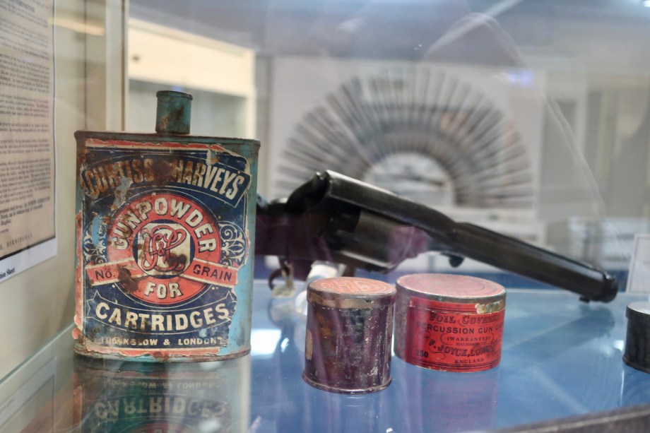 Old tins, gun and the Rising Sun rifle display in the background